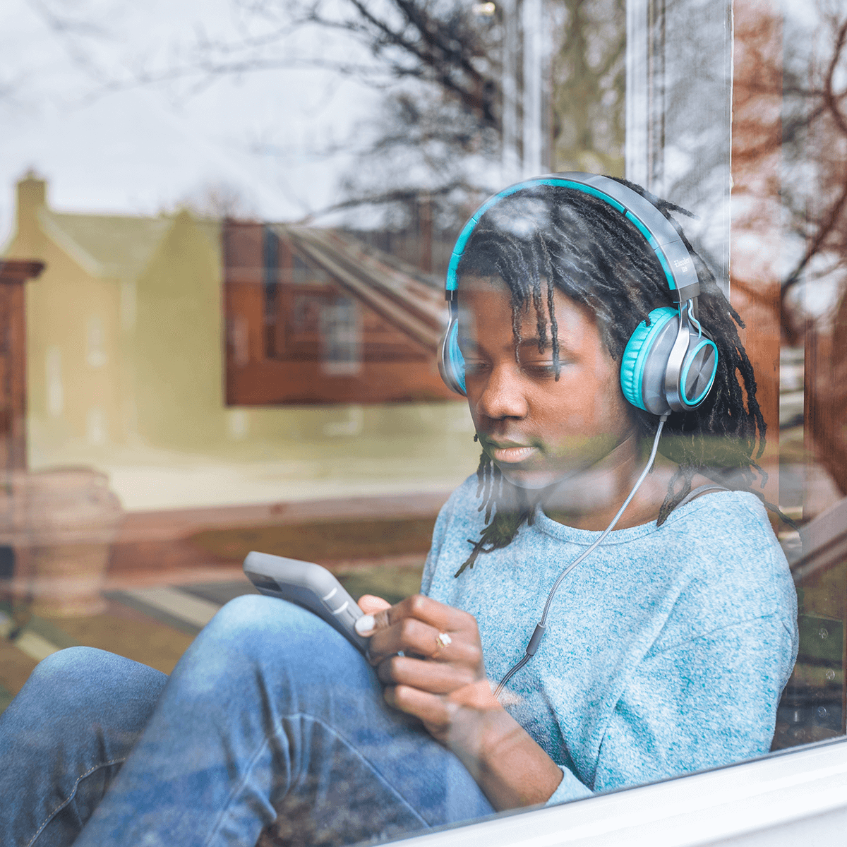 A young teenage boy listening to music on his mobile phone